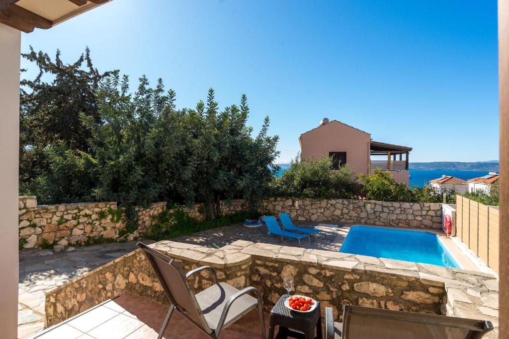 a backyard with a swimming pool and a house at Arto's Villa With Private Pool- BY APOKORONAS VILLAS in Plaka