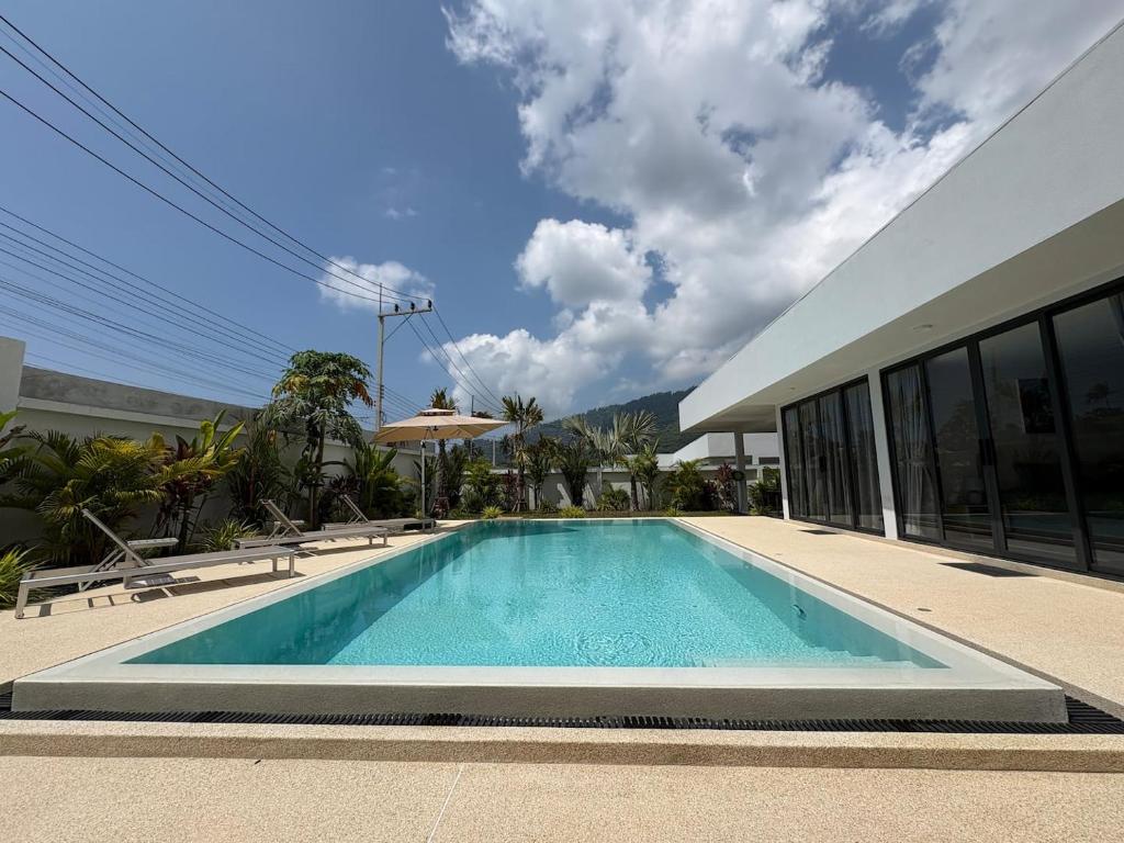 a swimming pool in front of a house at Coconut Villa 8 in Ban Thung