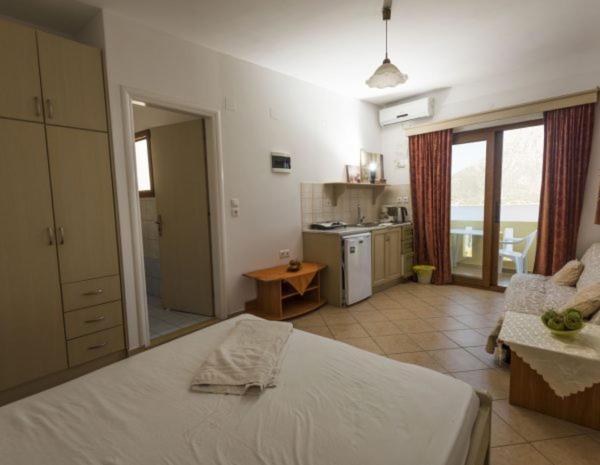a bedroom with a large bed and a kitchen with at Dimitrakis Studios in Masouri