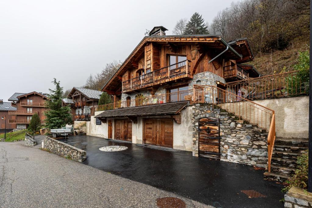 ein großes Holzhaus mit einem Balkon auf dem Dach in der Unterkunft Chalet Bordon in Champagny-en-Vanoise
