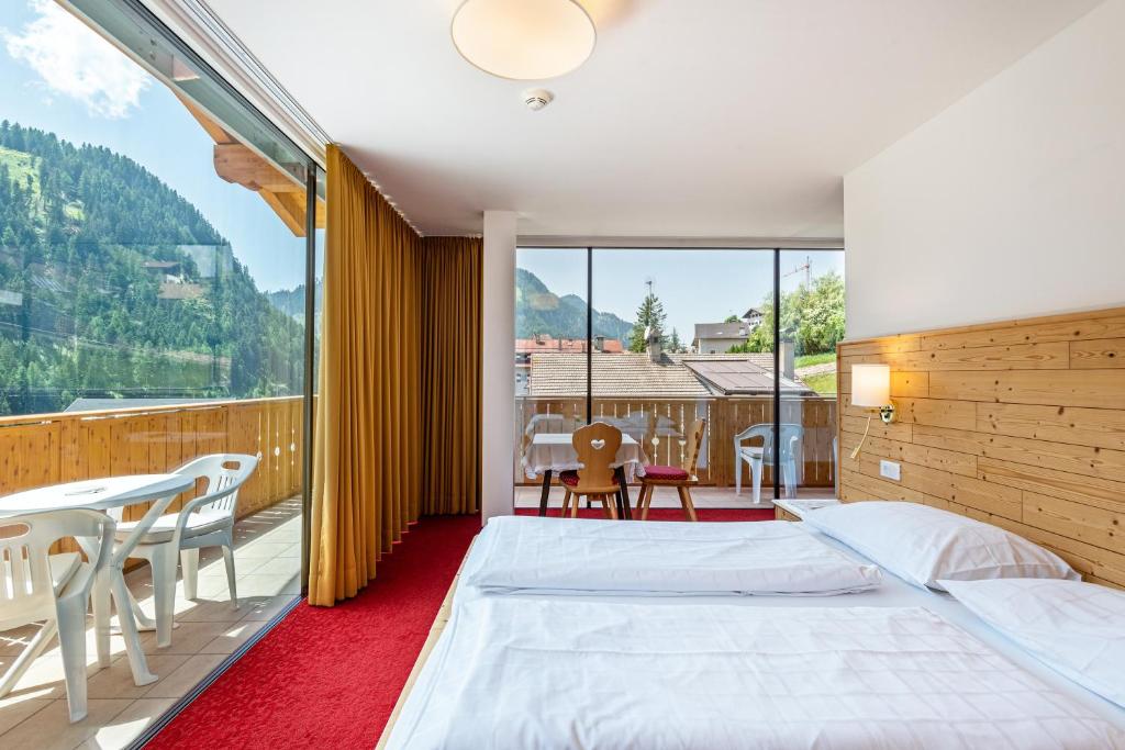a bedroom with a bed and a large window at Hotel Residence Gardena Stevia 307 in Santa Cristina Gherdëina