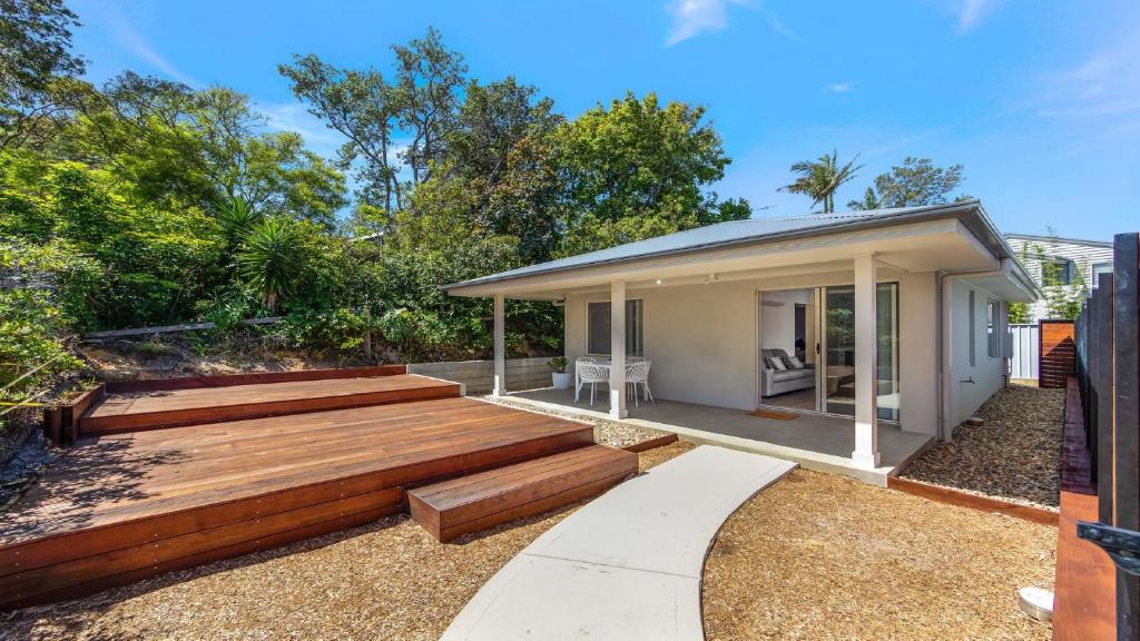 a home with a deck and a house at 'Coastal Harmony Cottage' by HolidayCo in Hardys Bay