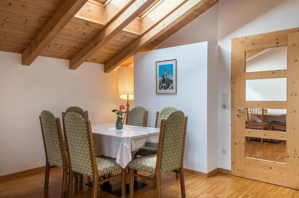 a dining room with a white table and chairs at Funtnatsch Apartment Schlern in Laion