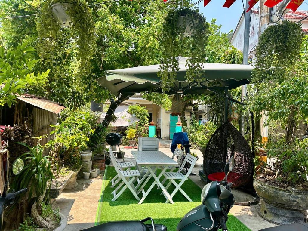a patio with a table and chairs and an umbrella at Quỳnh s House in Tân Hiệp
