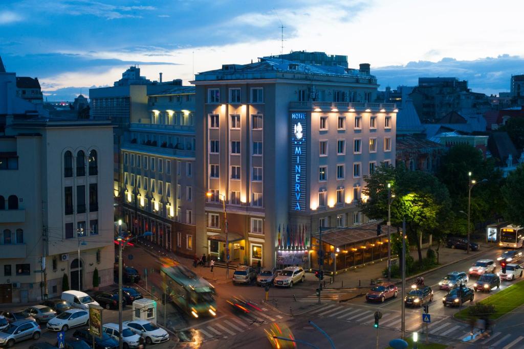 فندق مينيرفا في بوخارست: شارع المدينة فيه سيارات تقف امام مبنى