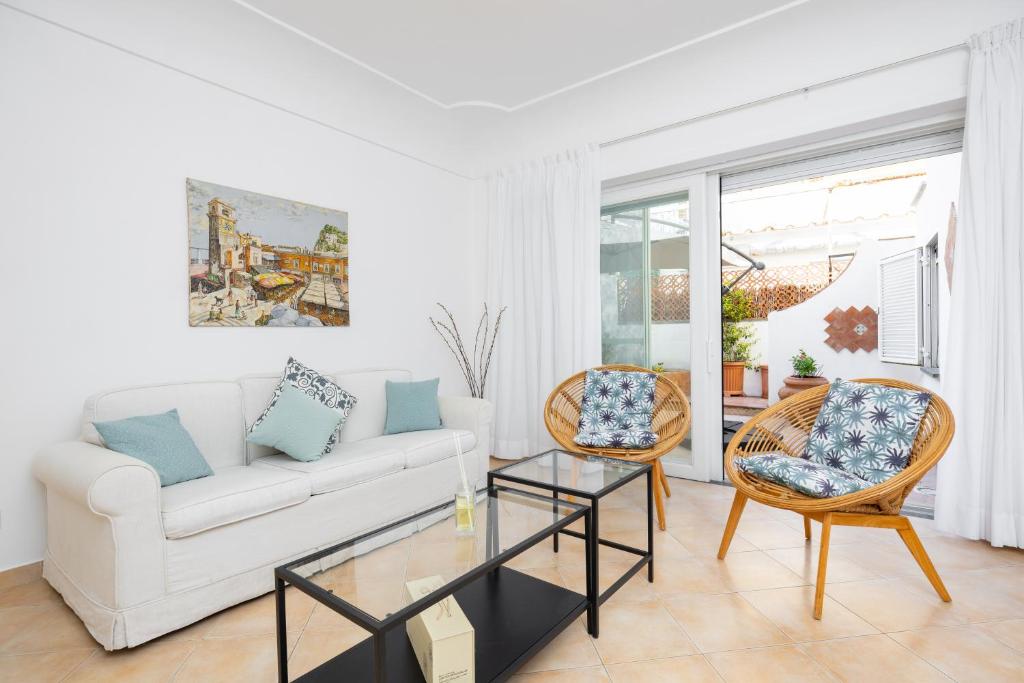 a living room with a white couch and two chairs at Birago22Capri in Capri