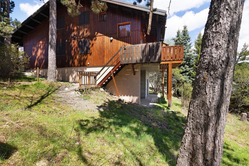 a log cabin with a porch and a deck at Petit chalet mitoyen Pyrénées 2000 in Bolquere Pyrenees 2000