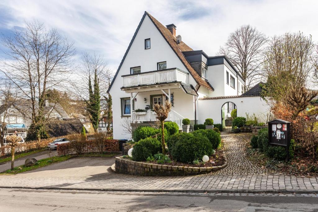 a white house with a black roof at Ferienwohnung Greitemann in Eslohe