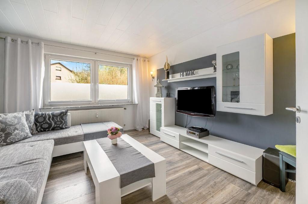 a living room with a couch and a tv at Ferienwohnung My Suite Home in Illingen