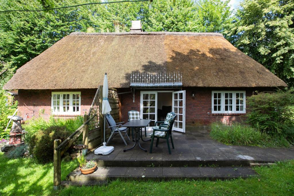 a small brick house with a table and chairs outside at Ferienhaus Reetkate Breklum in Breklum