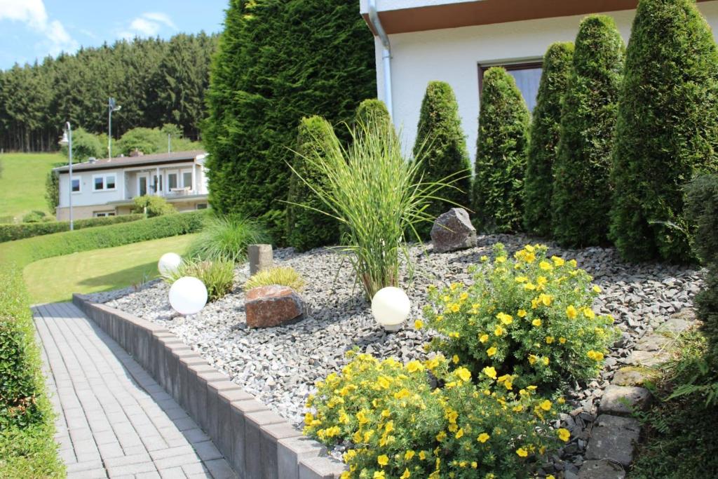 a garden with flowers and plants in front of a house at Ferienwohnung Tibo in Wimbach
