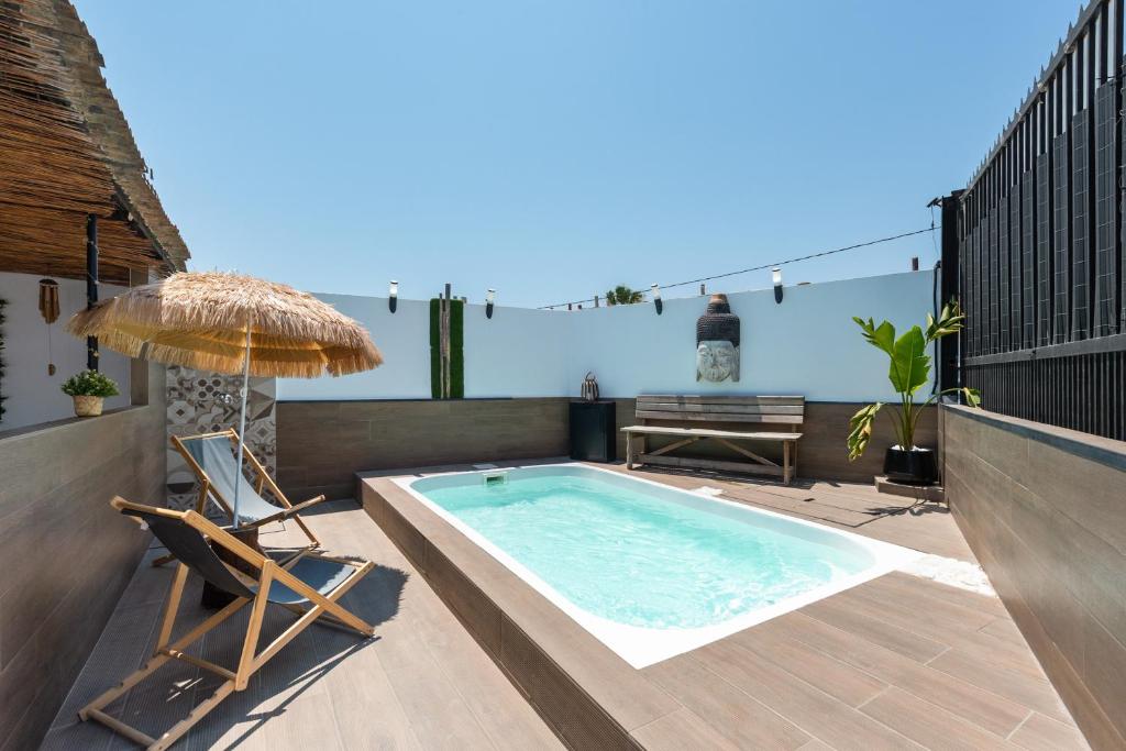 a patio with a swimming pool and a chair and an umbrella at Limón Lunero in Málaga
