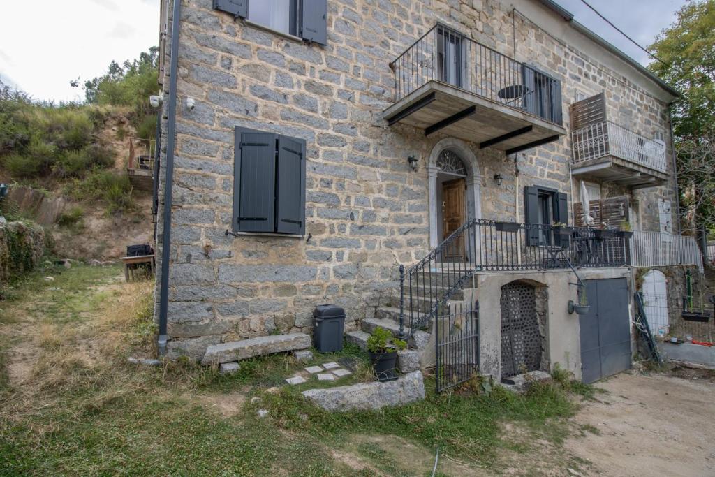 an old brick building with stairs and a balcony at A Casa D'amore in Bastelica