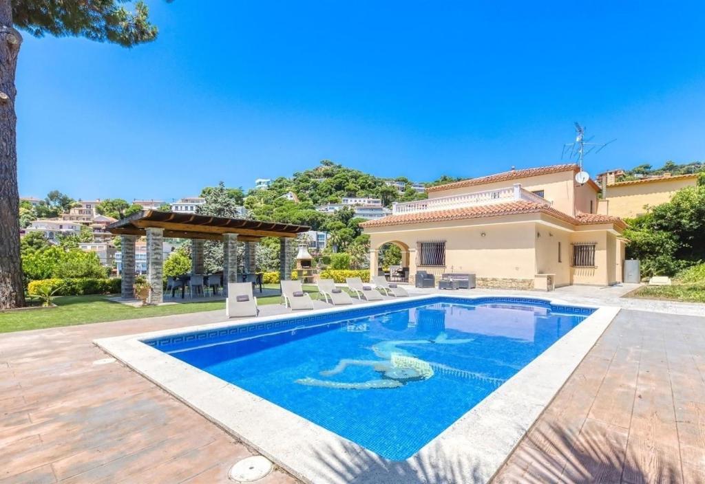 a swimming pool in the backyard of a house at Costacabana - Villa Paris in Lloret de Mar