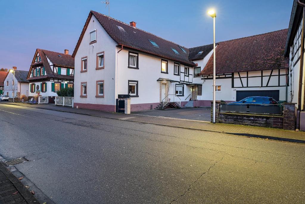 an empty street with white houses and a street light at Le Quartier Blackforest-Straßburg in Willstätt