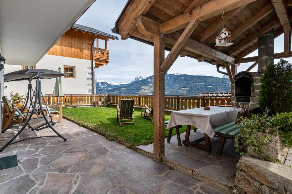 a patio with a table and an outdoor fireplace at Malsötscherhof Apt A in Villandro