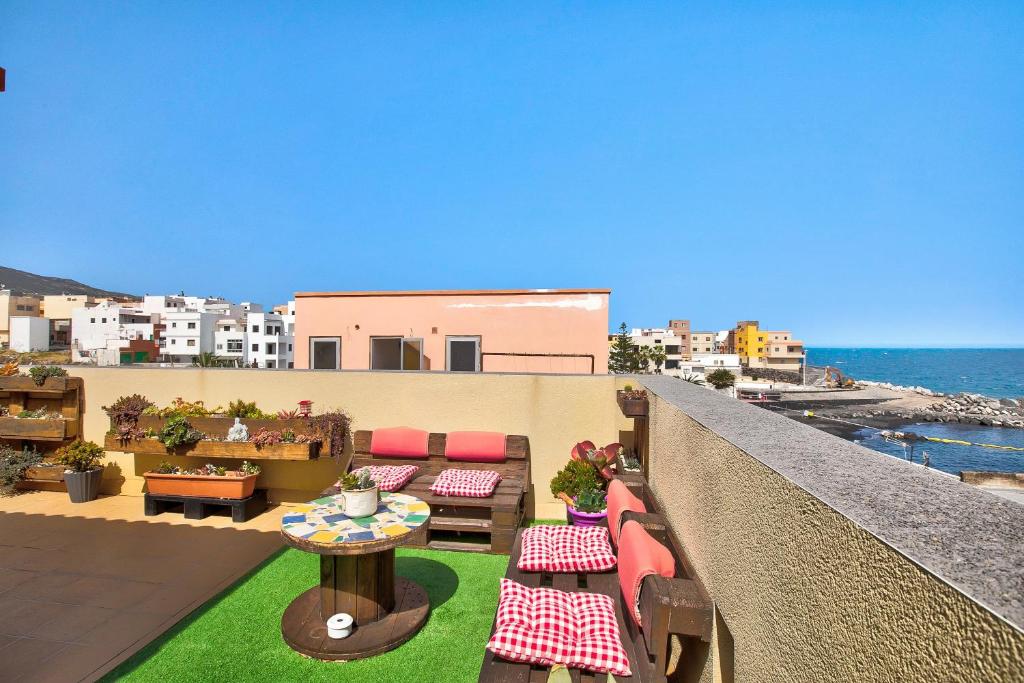 a balcony with tables and chairs and the ocean at Estudio Calima in Arico