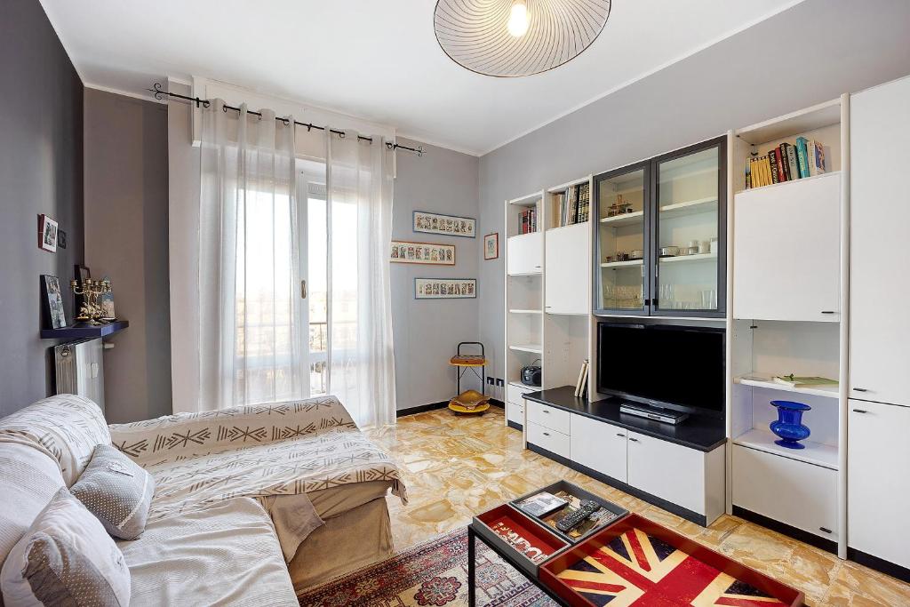 a living room with a couch and a tv at Casa Rose di Mare in Albenga