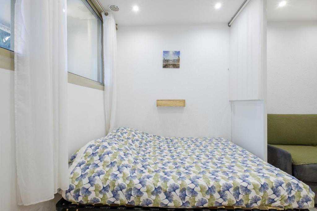 a small bedroom with a bed and a window at Studio - 2 couchages doubles in Villeneuve-Loubet