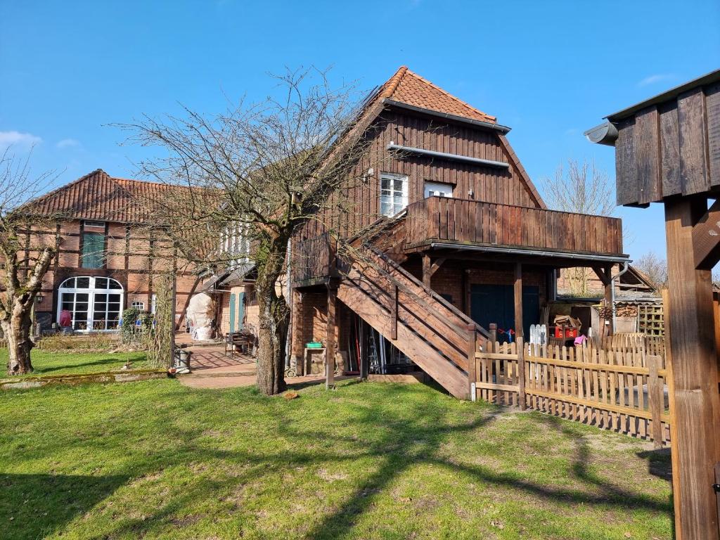a large house with a wooden fence in front of it at Ferienwohnung Oertzheide in Hermannsburg