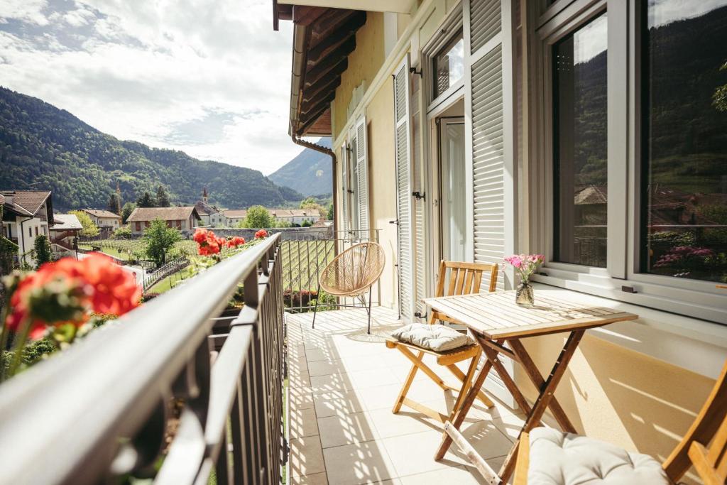 a balcony with a table and chairs on a house at Freienfeldhof Golden in Lagundo
