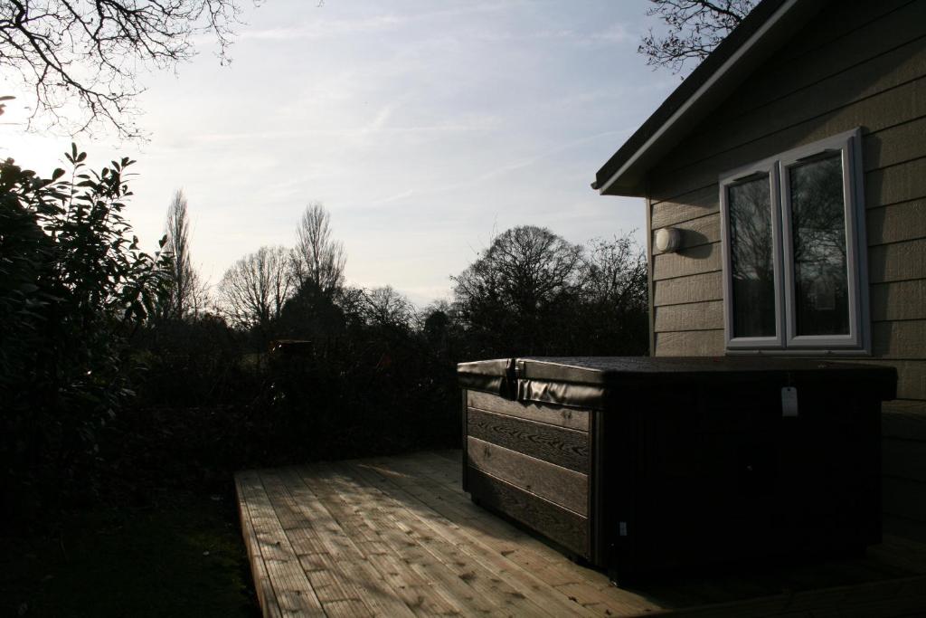 a house with a wooden deck next to a building at Golden Cross Holiday Park in Hailsham