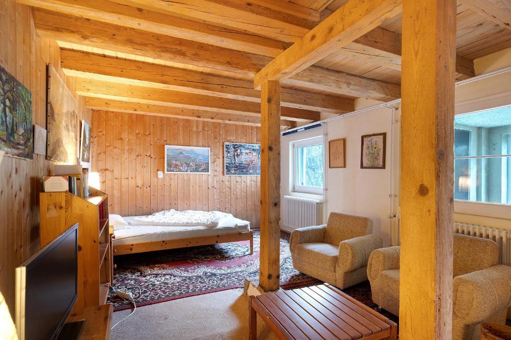 a room with a bed and a couch and a tv at Haus am Ufer in Gaienhofen