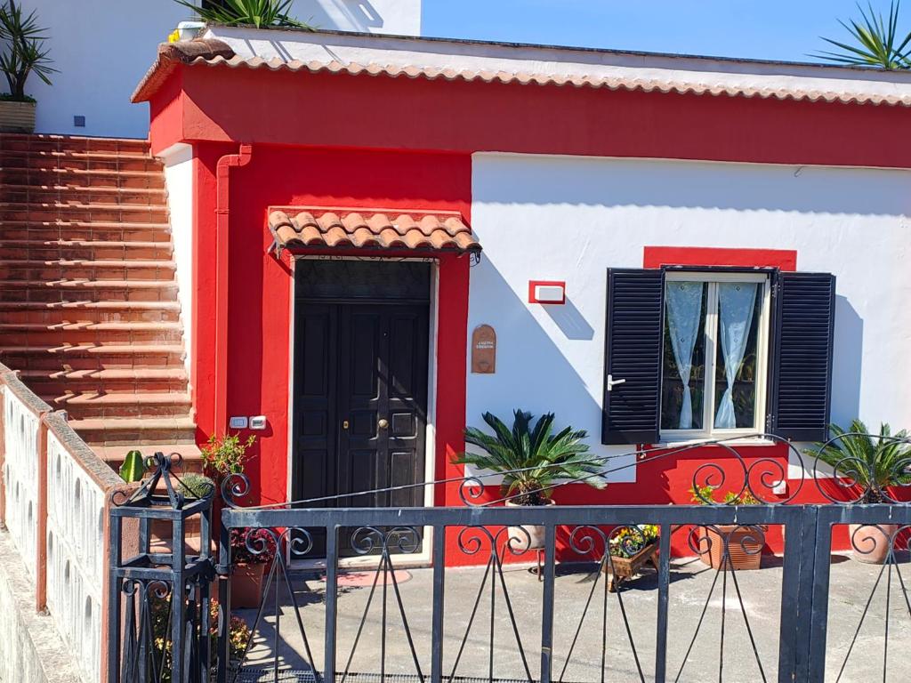 a red and white house with a black door at Casetta Esmeralda in Praia a Mare