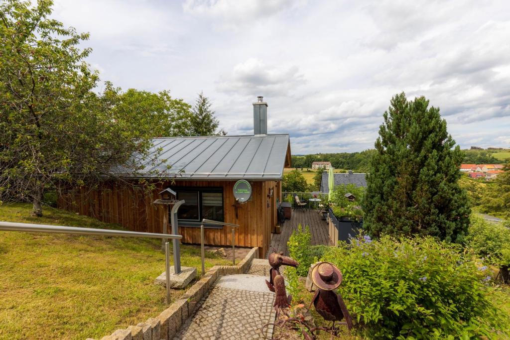 a small wooden house with two statues in front of it at Teufelsmauer-Blick in Thale