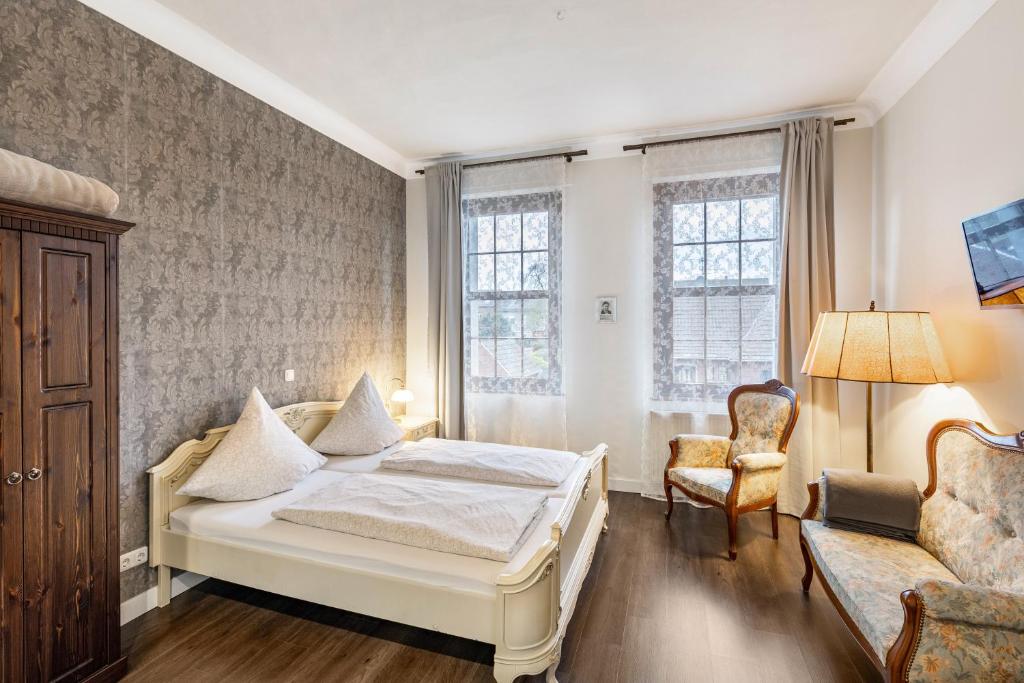 a bedroom with a bed and a couch and a chair at Nostalgie Apartment in Kerken
