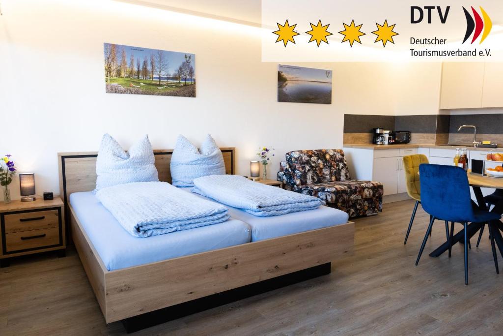 a bedroom with a bed and a table and a kitchen at Höri-Nest Abendsonne-Appartement in Gaienhofen