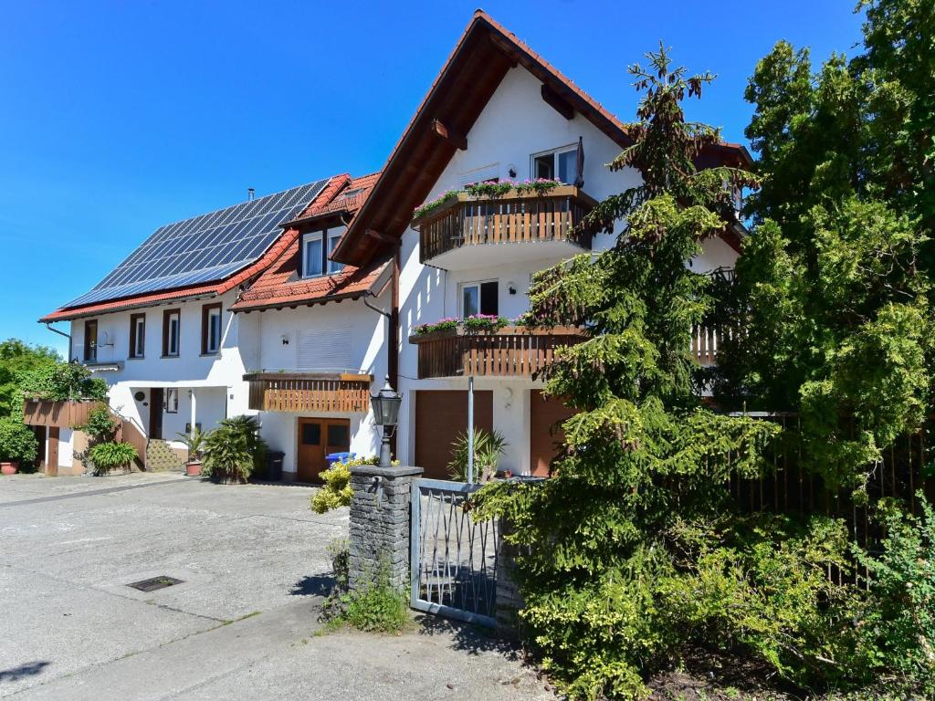 a white house with a fence and a tree at Ferienwohnungen Meyer in Hochbuch