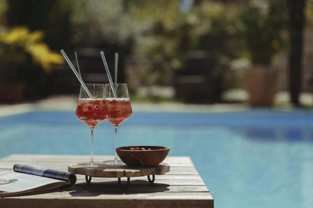 two wine glasses sitting on a table near a pool at Ferienwohnungen Winzerhof Keller in Auggen