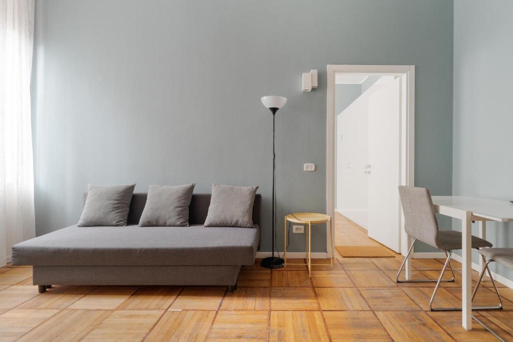 a living room with a couch and a table at GuestHost - Chic Flat Steps from Duomo in Milan