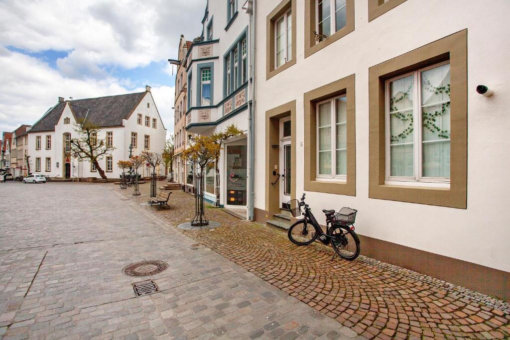a bike parked next to a building on a street at Fereinwohnung am Marktplatz in Warendorf