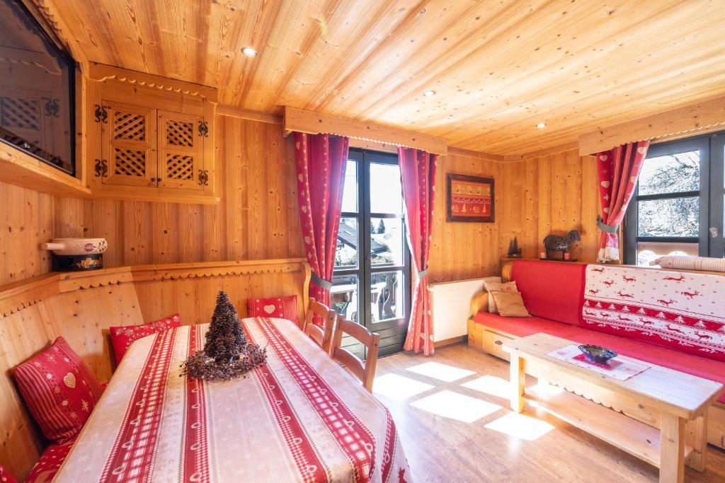 a room with a couch and a table in a cabin at Appartement les 4 As in Megève