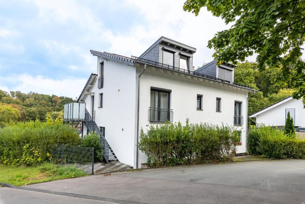 a white house with a black roof at Wohnung mit 3 Schlafzimmern in Solingen