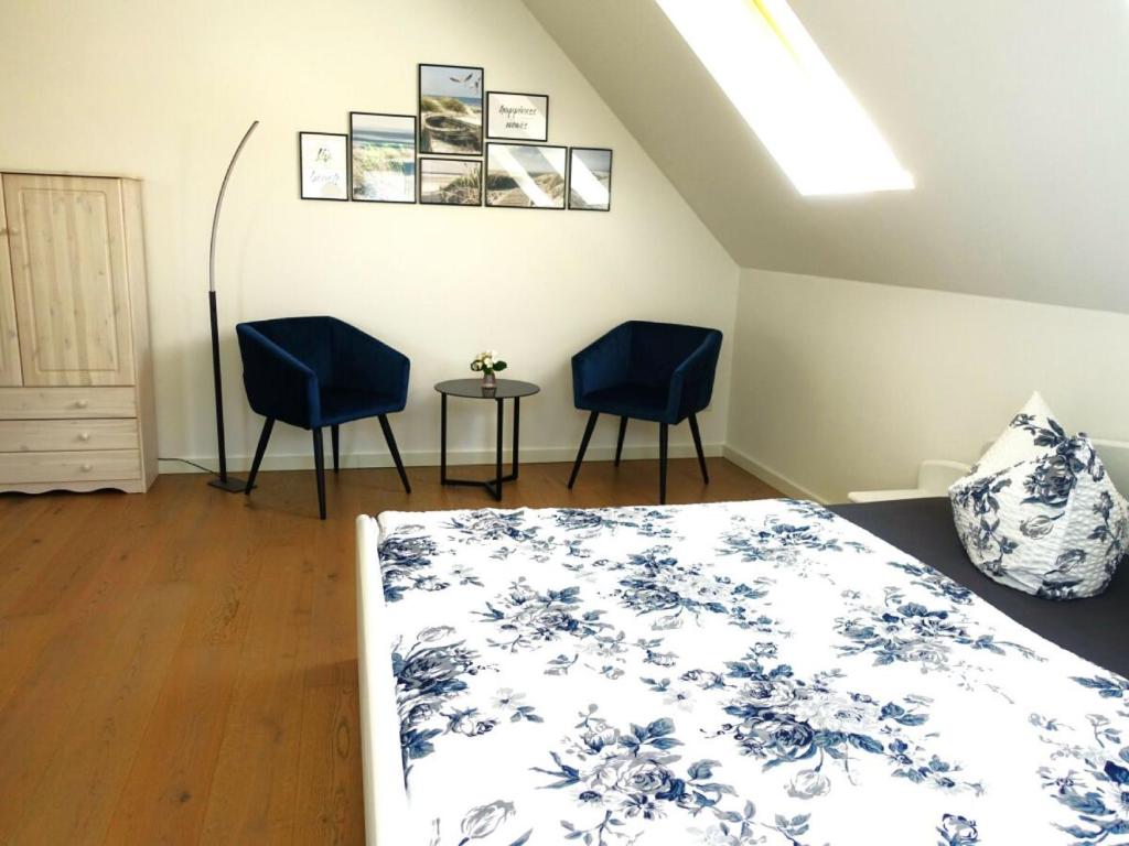 a bedroom with two blue chairs and a bed at Ferienhaus Melody in Ralswiek