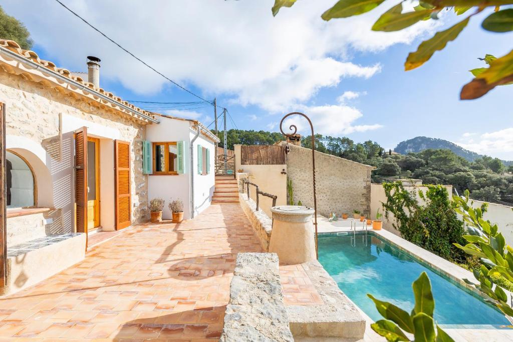 a villa with a swimming pool and a house at Can Titina in Puigpunyent