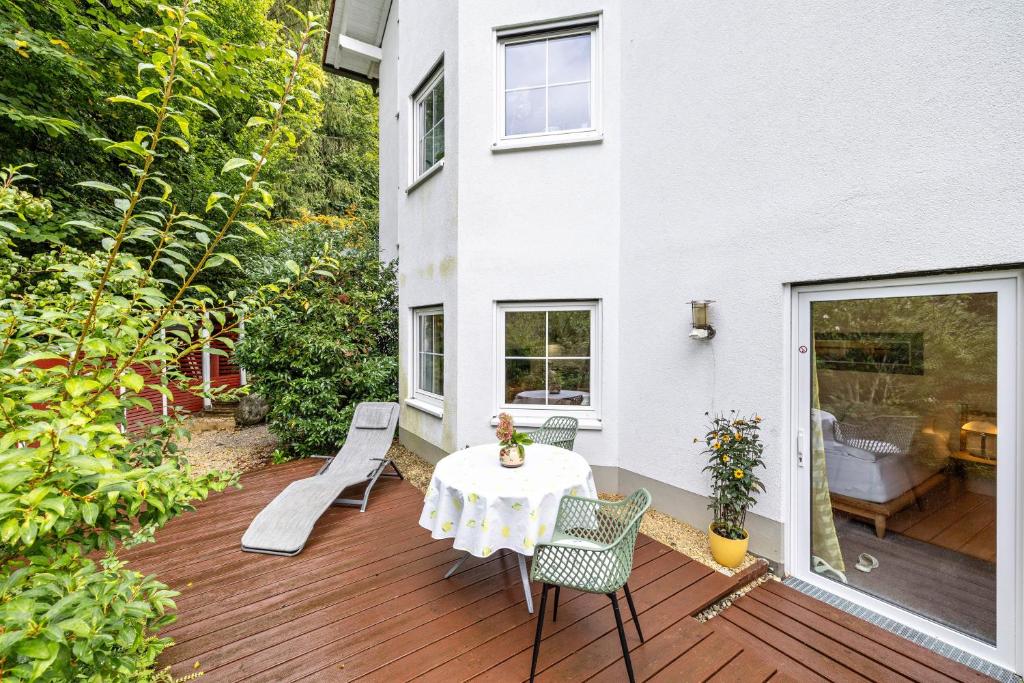 a patio with a table and chairs on a wooden deck at Ferienapartment Remke in Starnberg