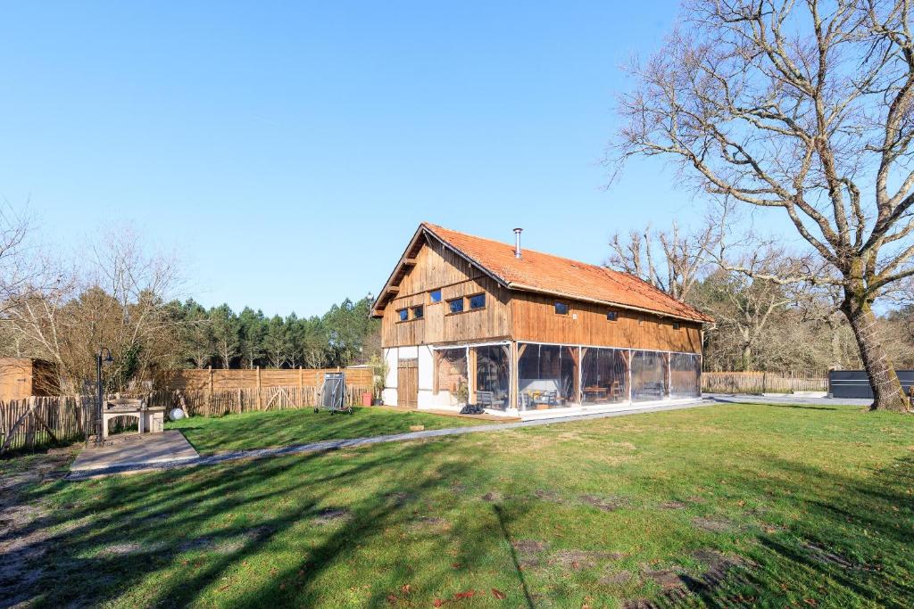 a large wooden barn with a large yard at Cuicui les p'tits oiseaux in Lesperon