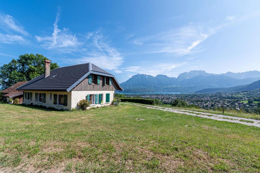 a house sitting on top of a grassy hill at Chalet des Bruyères in Saint-Jorioz