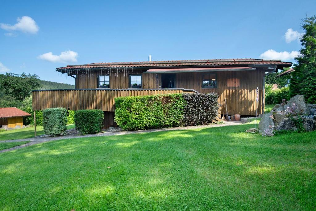 a house with a green yard in front of it at Pröllerhütte in Grün