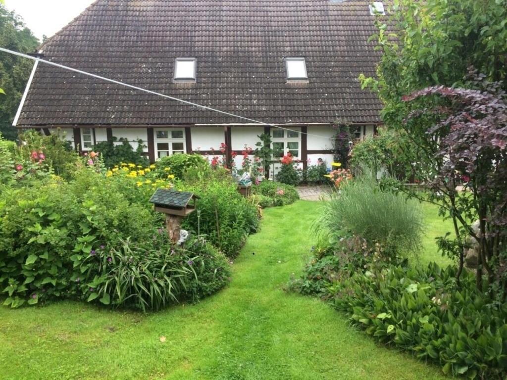 a garden in front of a house with flowers and plants at Fachwerkferienhaus in Ulrichshusen