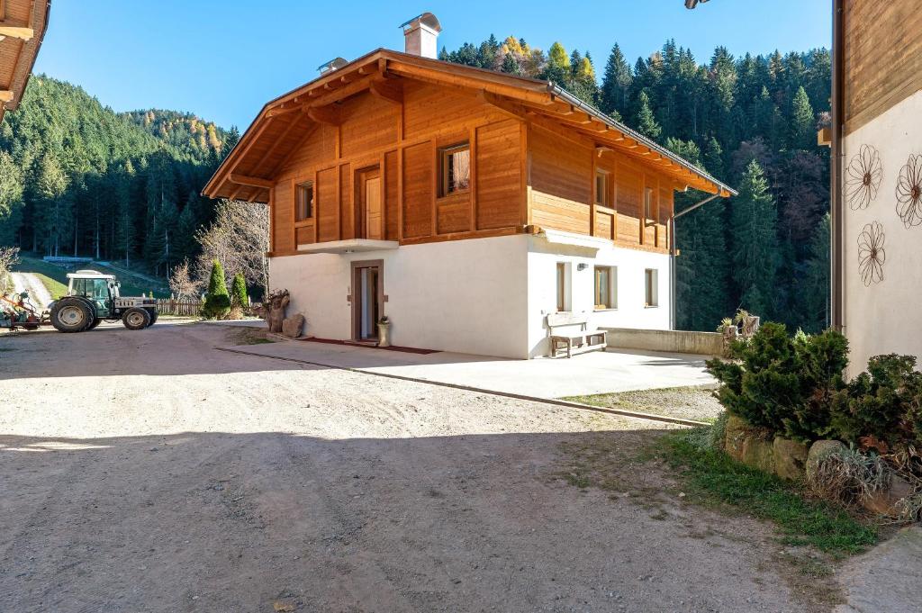 a house with a wooden roof on a street at Innerjerberhof Sunnseit in Lauregno