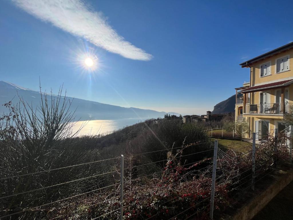 a building with a fence and a view of a lake at Residence La Villa Kalliste in Olzano