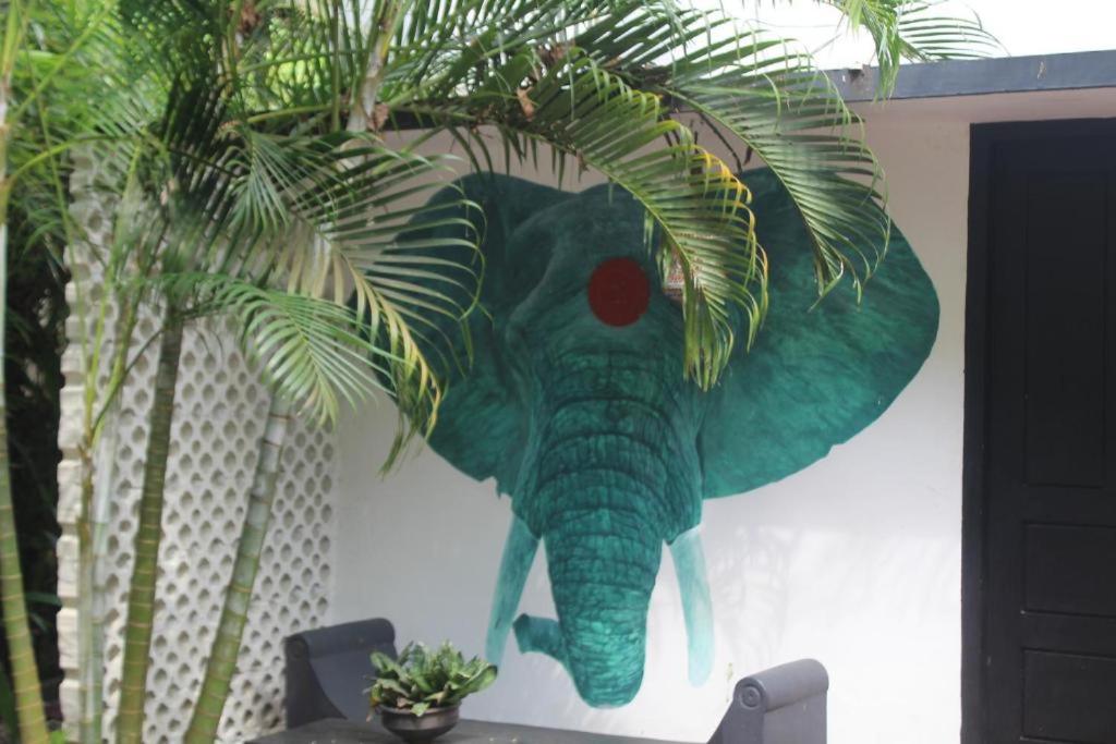 a painting of an elephant hanging on a wall at Mint Inside Garden in Varkala