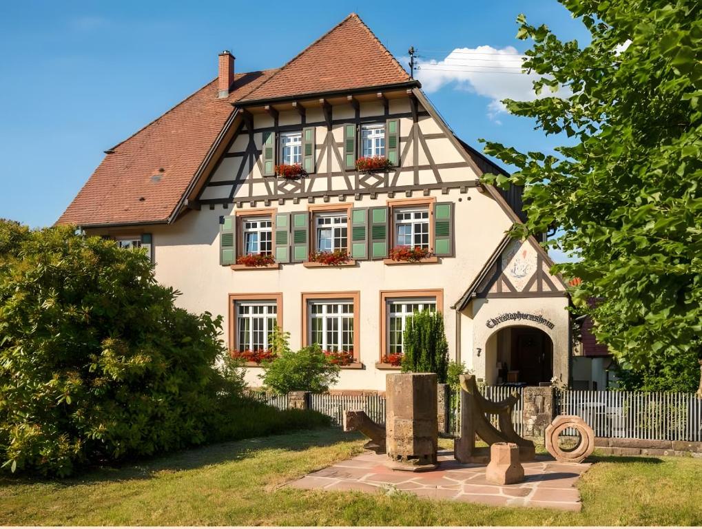 a house with a gambrel roof and green shutters at Landhaus Christophorus in Forbach