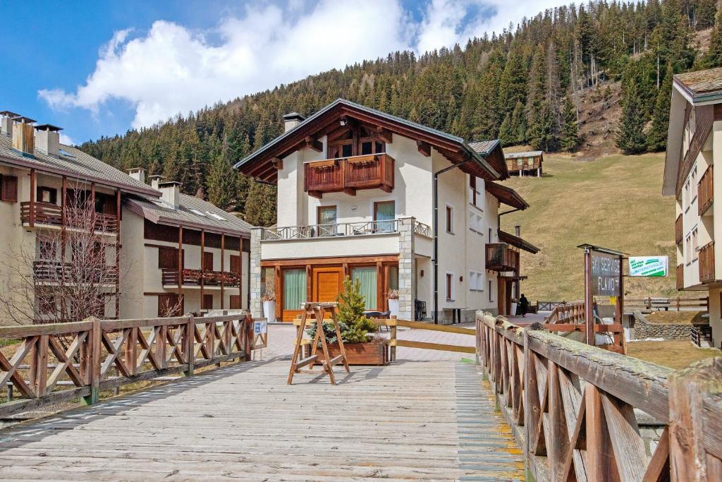 a building on a bridge with a wooden walkway at Chalet La Fiamma in Santa Caterina Valfurva