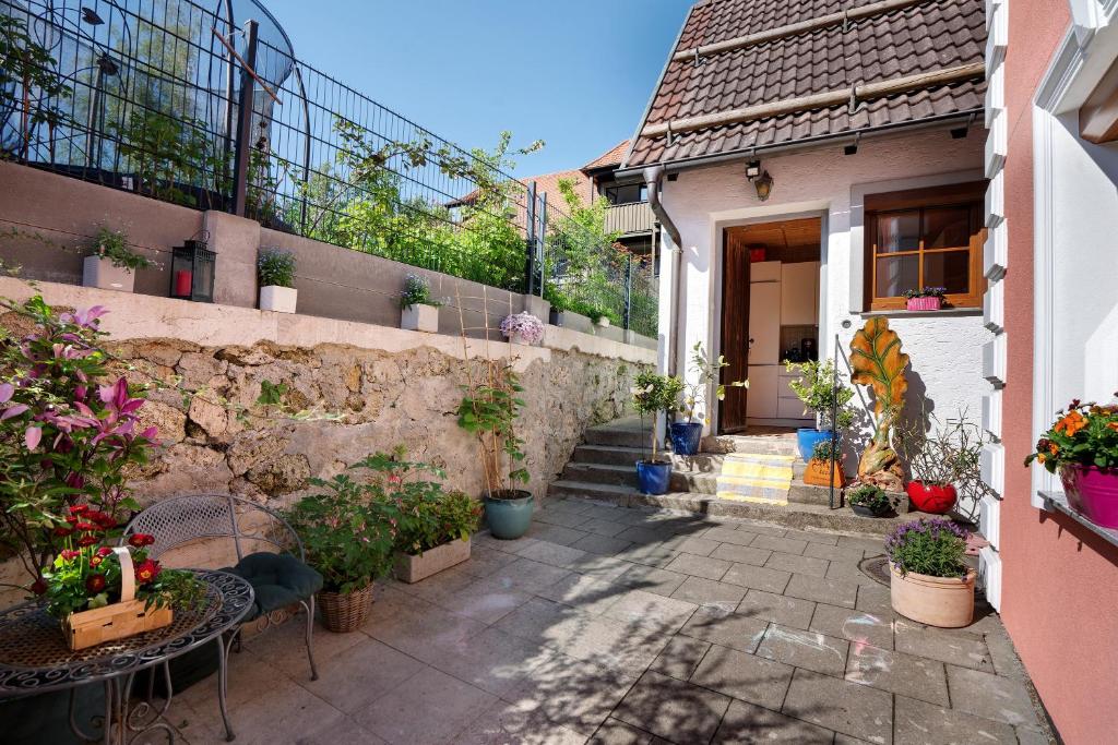 a patio with tables and potted plants in front of a house at Ferienhaus Ludava in Hofmarksgasse